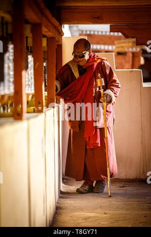 L'Inde, l'état de Jammu-et-Cachemire, Ladakh, Himalaya, vallée de l'Indus, moine de tourner les roues de prière dans la cour de la Gompa (monastère) de Hemis Banque D'Images
