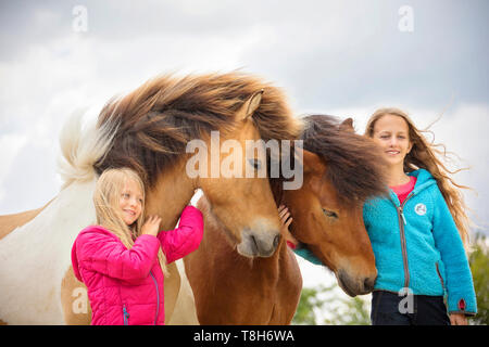 Cheval islandais. Deux filles smooching avec deux chevaux adultes. L'Autriche Banque D'Images