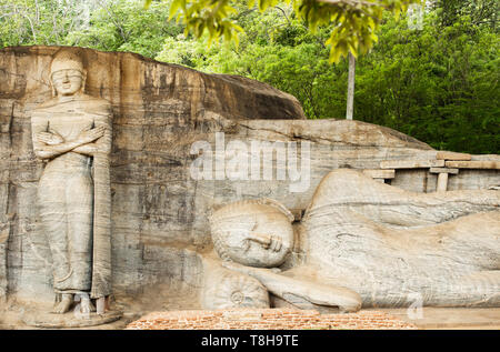 Vue imprenable sur la très belle statue du Bouddha couché et moine Ananda sculpté dans la pierre. Banque D'Images
