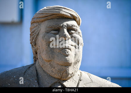 Le Président américain Donald Trump sur le visage d'un Brexit sculpture à thème au Festival de sculptures de sable, Weston Weston-super-Mare. La sculpture lorsqu'il sera terminé, le Royaume-Uni disposent de séparer l'Europe sur un globe avec Donald Trump à l'ouest avec ses accords commerciaux et Vladimir Poutine à l'est appuyée sur un écran d'ordinateur affichant de fausses nouvelles. Banque D'Images