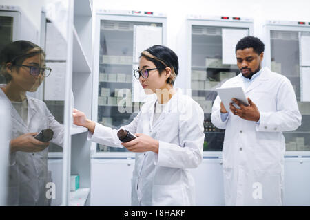 Pharmacien asiatique salle de stockage des médicaments dans les tri Banque D'Images