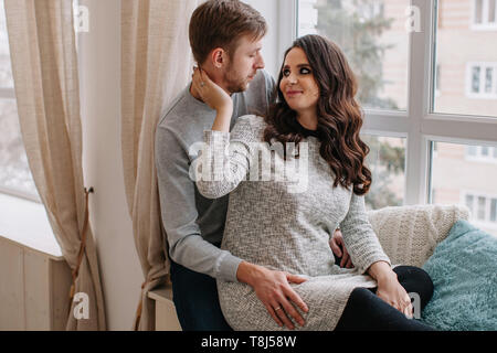 Smiling couple sitting by a Window Banque D'Images