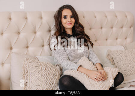 Portrait of a smiling woman sitting on a bed Banque D'Images