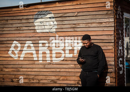 Amos Mgodini debout devant sa boutique de coiffeur appelé Ayas dans Wallacedene, Cape Town, Afrique du Sud. Banque D'Images