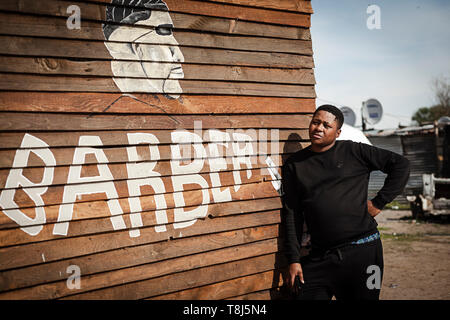 Amos Mgodini debout devant sa boutique de coiffeur appelé Ayas dans Wallacedene, Cape Town, Afrique du Sud. Banque D'Images