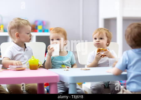 Groupe d'enfants ont breaktime manger au centre de garde Banque D'Images