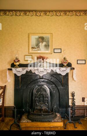 Le Canada, l'Île du Prince Édouard, Park Corner, Anne of Green Gables Museum, ancienne maison des Campbells, parents d'Anne aux pignons verts Lucy Maud Montgomery, cheminée avec Portrait de Lucy Maud Montgomery Banque D'Images