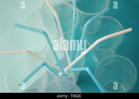 La paille en plastique bleu et blanc pour des cocktails et jus de tubules sur fond bleu turquoise. L'intérieur des tubules en plastique tasses Banque D'Images