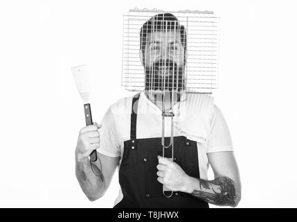 Hipster barbu porter un tablier pour barbecue. La cuisson des viandes conseils. Outils pour la viande à rôtir en plein air. Comment choisir la viande pour steak et barbecue. Menu barbecue. Pique-nique et barbecue. Le rôtissage et la cuisson des aliments. Banque D'Images