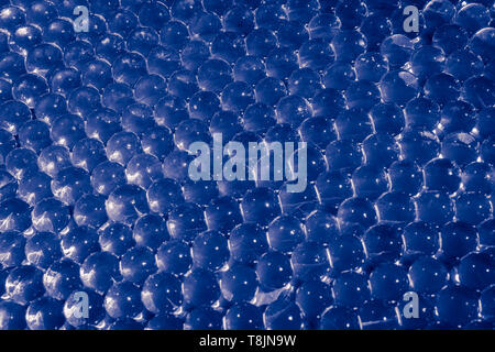 Gel bleu de l'eau avec des boules de bokeh. Gel de polymère. Gel de silice. Boules de blue hydrogel. Crystal Ball liquide avec la réflexion. Blue Balls texture background Banque D'Images