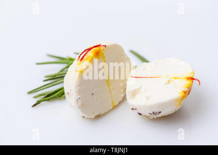 Deux moitiés de fromage boule avec brin de thym sur fond blanc. Banque D'Images