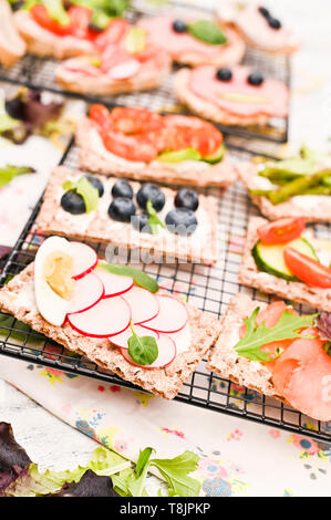 Sandwiches différents pour le petit déjeuner on a white background. Craquelins aux crevettes, légumes, fromage et jambon Banque D'Images