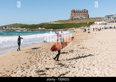 Leurs Surfers carrying surfboards marchant sur la plage de Fistral à Newquay en Cornouailles. Banque D'Images