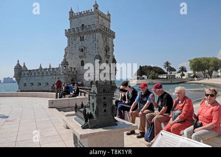 Les personnes âgées touristes personnes des couples visiter la Tour de Belém assis à l'extérieur par un modèle miniature réplique de capacités à Belem Lisbonne Portugal KATHY DEWITT Banque D'Images