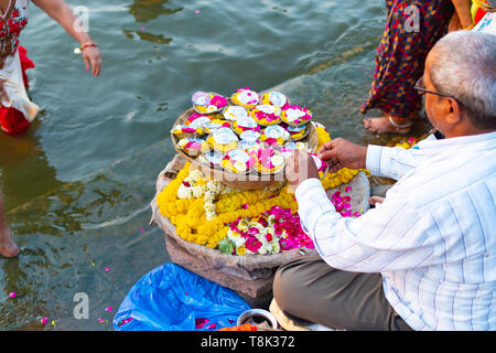 Varanasi, Inde, 27 mars 2019 - l'homme Indien pooja vente articles fleurs pour le placement. Banque D'Images