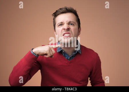 Man gesturing avec index à son cou Banque D'Images