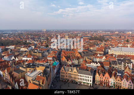 Ville fantastique avec des toits de tuiles rouges et une partie de la Place du Marché (Markt) en journée d'hiver ensoleillée. Vue de la ville médiévale de Bruges par le haut. Banque D'Images