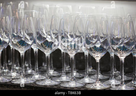 Verres à vin vide sur une étagère ou un comptoir sous les lumières vives dans un pub ou un bar avec des reflets dans le verre Banque D'Images