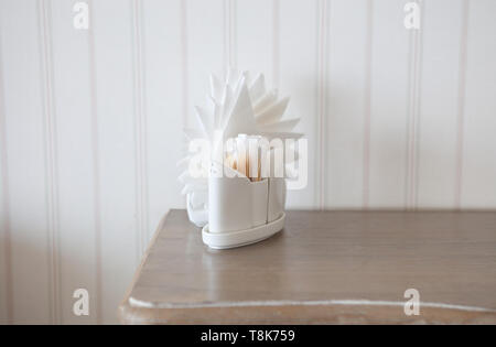 Serviettes blanches dans les supports sur table en bois Banque D'Images