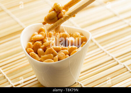 Manger santé soja fermenté traditionnel japonais appelé natto avec des baguettes Banque D'Images