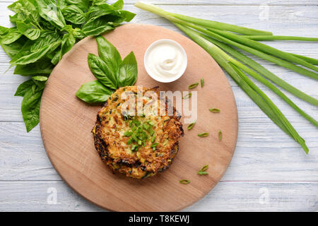 Crêpes de courgettes avec la sauce et les herbes sur planche de bois Banque D'Images