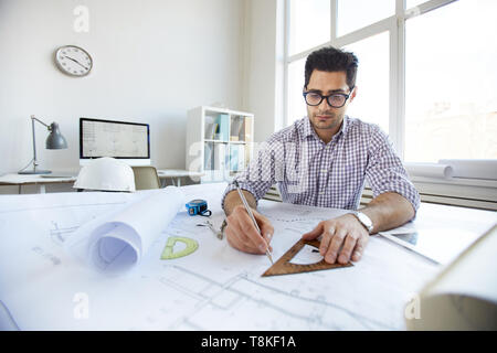 Jeune ingénieur des plans de dessin Banque D'Images