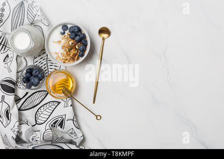 Espace libre pour le texte avec le muesli, myrtilles, miel et yogourt, cuillère et serviette. Ingrédients pour un petit-déjeuner sain, concept d'alimentation nourriture, télévision, Banque D'Images