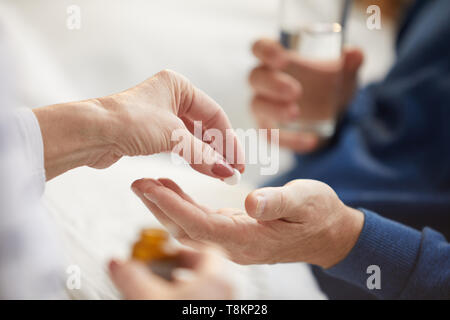 Donner des pilules pour Senior Man Banque D'Images