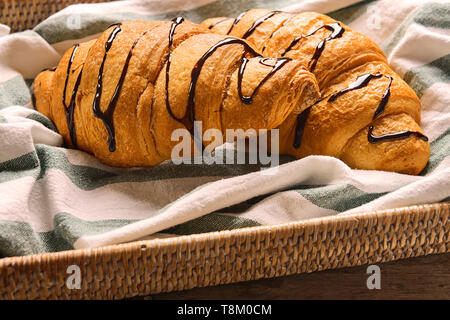 Plateau avec de délicieux croissants et de sirop de chocolat sur la table Banque D'Images