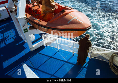 Un homme portant une djellaba marocaine ressemble à l'eau de mer depuis le pont d'un ferry traversant le détroit de Gibraltar entre Tanger, Maroc, et Algec Banque D'Images