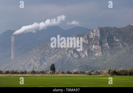 La pollution de l'écologie. La vapeur blanche vient du tuyau. L'usine de l'industrie sur le terrain. Arrière-plan du paysage. Banque D'Images