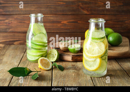 Bouteilles de limonade citron vert frais sur table en bois Banque D'Images