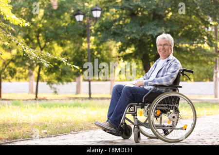 Happy senior man in wheelchair outdoors Banque D'Images