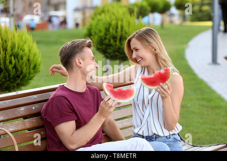 Cute young couple eating watermelon on date romantique en plein air Banque D'Images