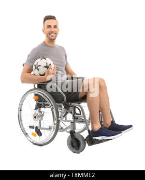 Jeune homme avec ball assis en fauteuil roulant sur fond blanc Banque D'Images