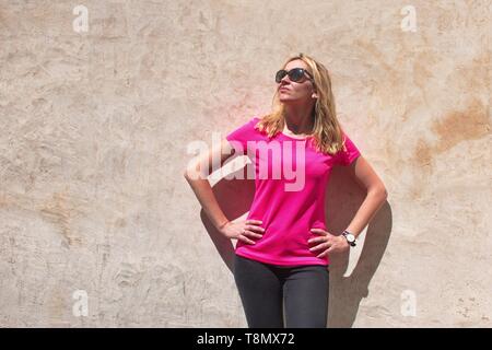 Jeune femme debout devant le mur Banque D'Images