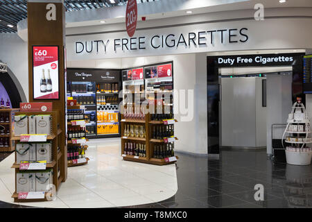 L'intérieur de la zone de shopping hors taxes à l'aéroport de Stansted montrant la section séparée pour les cigarettes hors taxes et l'affichage des bouteilles d'alcool, Banque D'Images