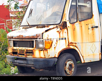 Le rouillé, délabrées et ancienne cabine d'une camionnette, sans une licence plate, plein de boîtes et corbeille, garé dans un parking. Banque D'Images