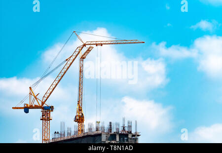 Site de construction avec grue et bâtiment. Secteur de l'immobilier. L'utilisation de grues de levage du rabatteur de l'équipement dans la construction du site. La construction en acier et Banque D'Images