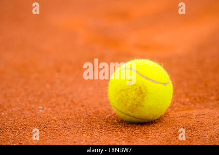 Balle de tennis sur un court de tennis en terre battue Banque D'Images