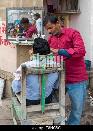 Salon de coiffure en plein air sur les ghats du Gange, Varanasi, Inde Banque D'Images