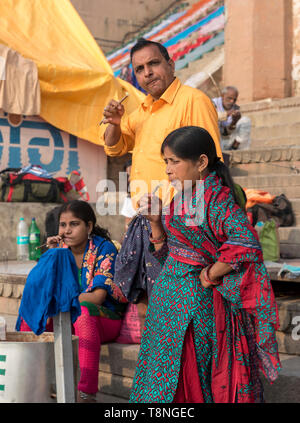 Famille indienne, brosser les dents avec une brindille sur les ghats du Gange, Varanasi, Inde Banque D'Images
