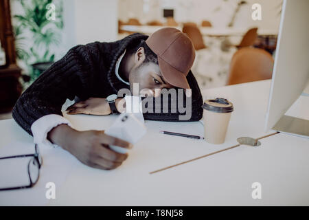 L'homme travail épuisé et dort sur un ordinateur portable avec téléphone mobile à l'espace de travail en bois Banque D'Images