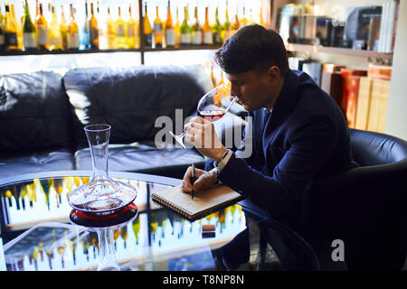 La construction d'une grande carte des vins. young attractive man giving recommandation de vin. close up side view photo Banque D'Images