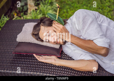 Homme ayant un traitement de bougie d'oreille à la maison Photo Stock -  Alamy