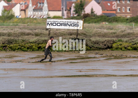 Gagnant Christopher Lee en marche le long de la rivière à la course dans la boue de Maldon la rivière Blackwater, Maldon, Essex, Royaume-Uni. Banque D'Images