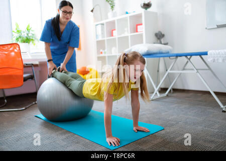 Peu actif sur l'exercice patient blonde balle Pilates Banque D'Images