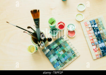 Outils de dessin dans un verre de céramique et de peinture sur une table en bois Banque D'Images