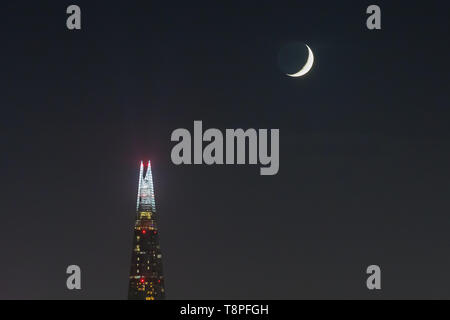 Un croissant de lune est appréciée sur les gratte-ciel d'échardes dans la semaine qui commence le Ramadan, Londres, Royaume-Uni. Banque D'Images