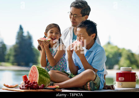 La pastèque en famille au cours d'un pique-nique au parc. Banque D'Images